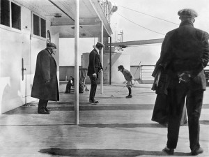 Robert Douglas Spedden, observado por su padre Frederic, juega en la cubierta del Titanic con un trompo.  Imagen: Padre Frank Browne (1912)