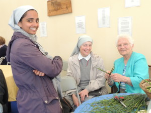 Juli Thottungal y Lucyna Wisniowska, Hermanas de San Pedro Claver, y Kay Mulhall de las Brigidinas, quien está tejiendo una cruz de Santa Brígida.