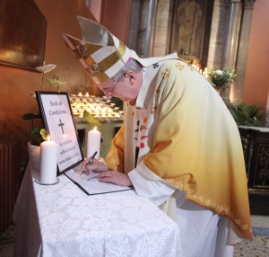 El arzobispo Diarmuid Martin de Dublín firma el libro de condolencias en la Catedral St Mary's Pro después de una misa para recordar a las víctimas de las tragedias de París.  Imagen John Mc Elroy. 