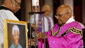 El arzobispo Desmond Tutu, amigo del difunto Nelson Mandela, reza ante una fotografía del expresidente de Sudáfrica.  Foto: Cortesía: BBC